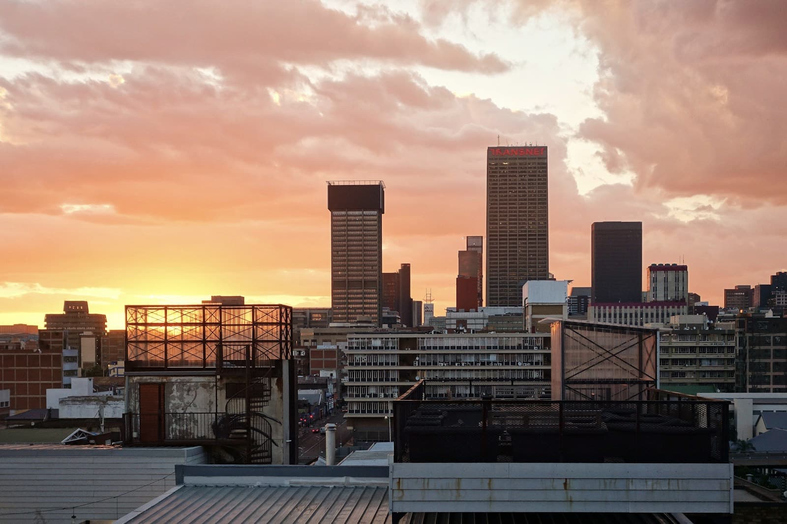 Johannesburg city towers silhouetted against a sunset sky
